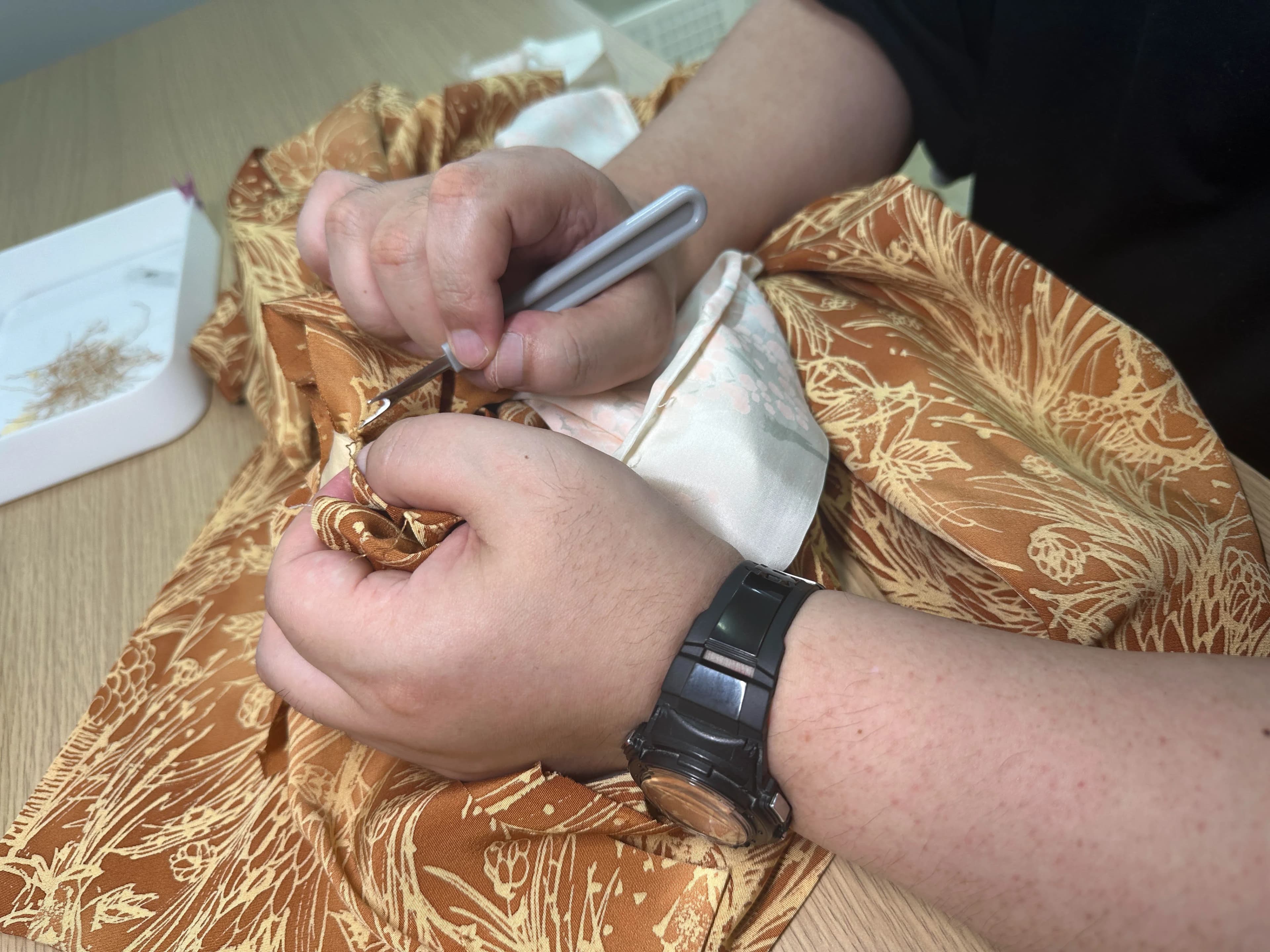 着物の縫い目を解く手元の作業の様子